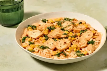 Bol de poulet crémeux au maïs sur un lit de riz